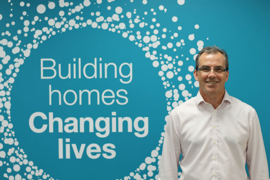 Building home Changing lives backdrop with Jonathan Higgs in photo