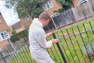 Raven team member painting railing